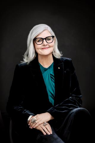 the Governor-General, sitting with her hands crossed